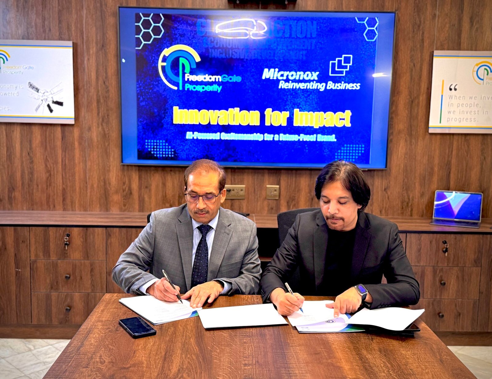 Muhammad Anwar and Asad Rafi signing the MOU