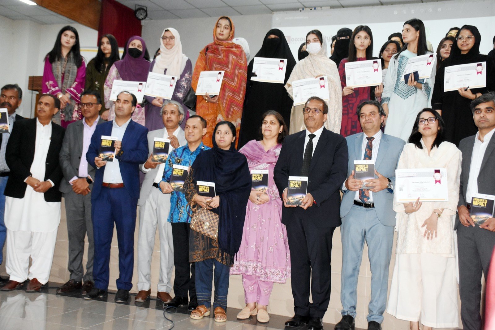 Participants receiving copies of From Idea to Impact and certificates